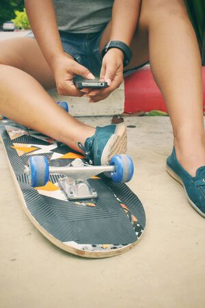 Selfie of young girl and smart phone with skateboardの写真素材