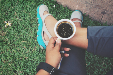 coffee cup in hands with shoes