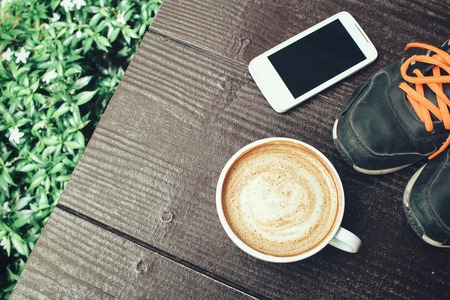 Latte coffee and smartphone with sneakersの写真素材