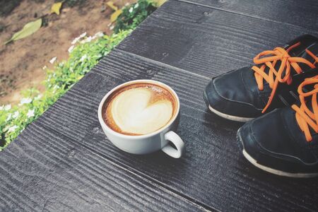 Vintage latte art coffee with sneakersの写真素材