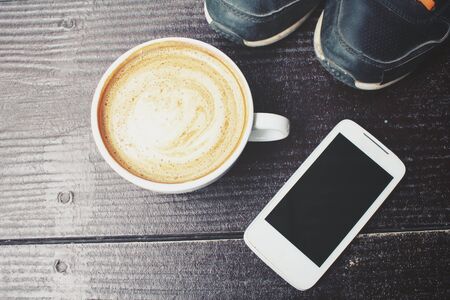 Latte coffee and smartphone with sneakersの写真素材