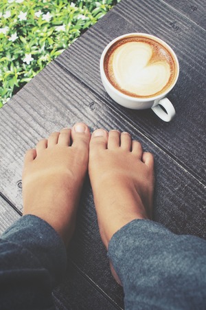 Selfie of coffee with feet in the gardenの写真素材