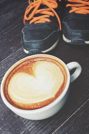 Vintage latte art coffee with sneakersの写真素材