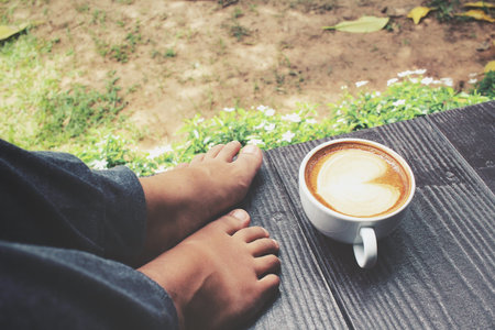 Selfie of coffee with feet in the gardenの写真素材