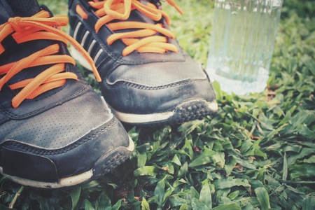 Sport shoes with water drink on green grassの写真素材