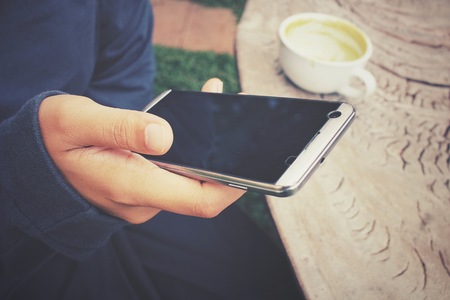 Woman using smart phone with green teaの写真素材
