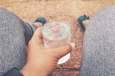 Selfie of drink water on hand with shoesの写真素材