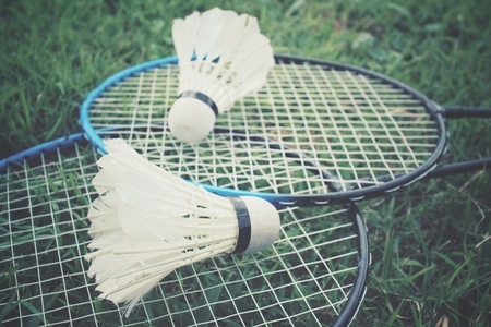 Shuttlecocks with badminton racket on green grassの写真素材