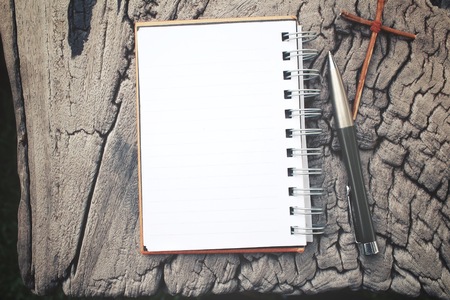 Blank notepad and pen with crossの写真素材