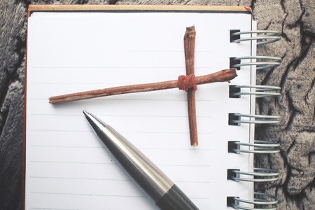 Blank notepad and pen with crossの写真素材