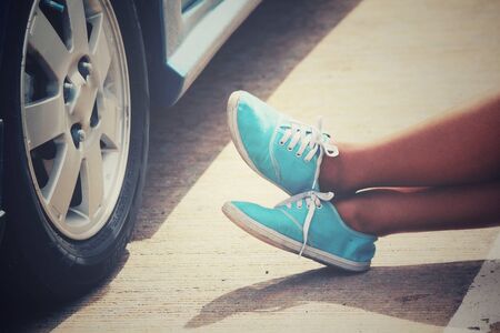 Woman with sneaker and car on the roadの写真素材
