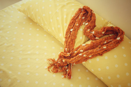 Heart of scarf on bed pillows at hotel