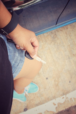 Selfie of sneaker with key car on handの写真素材