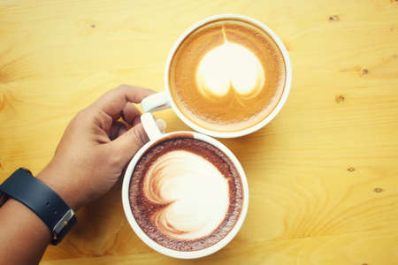 Vintage latte art coffee with hot chocolateの写真素材