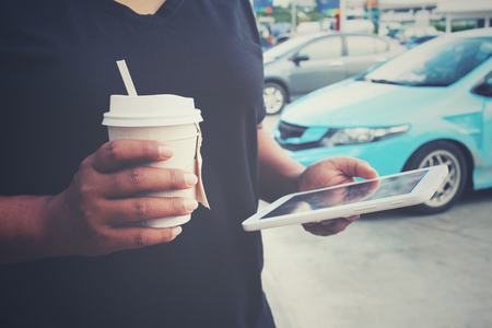 Woman using tablet with coffee paper cupの写真素材