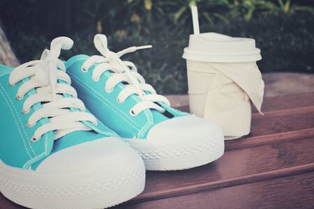 Coffee paper cup with sneakersの写真素材