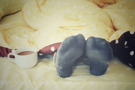 Woman drinking coffee on the bedの写真素材