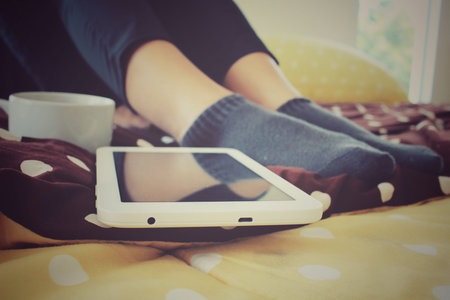 Tablet with coffee cup on the bedの写真素材