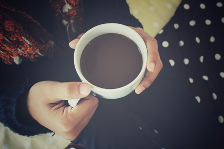 Woman drinking coffee on the bedの写真素材