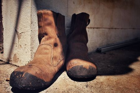Old boots with shadowの写真素材
