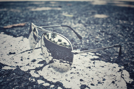 Sun glasses with reflection and road