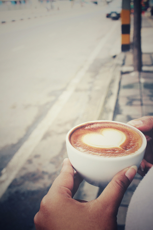 Woman drinking latte art coffeeの写真素材
