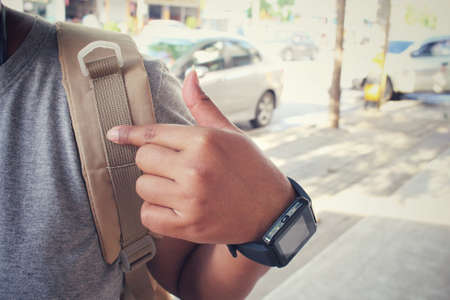 Woman tourist with a backpack standing on roadの写真素材