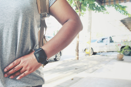 Woman tourist with a backpack standing on roadの写真素材
