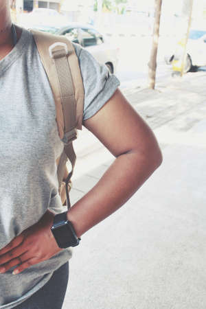 Woman tourist with a backpack standing on roadの写真素材