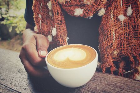 Woman with a scarf and drinking coffeeの写真素材