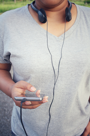 Woman listening to music on earphone with smart phoneの写真素材