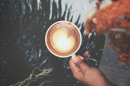 Selfie of hand with drinking coffee cupの写真素材