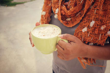 Woman with scarf and drinking coffeeの写真素材