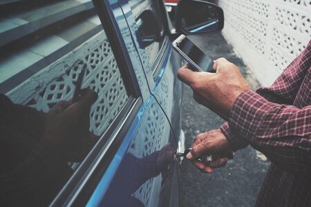 Man open the door car with smart phoneの写真素材