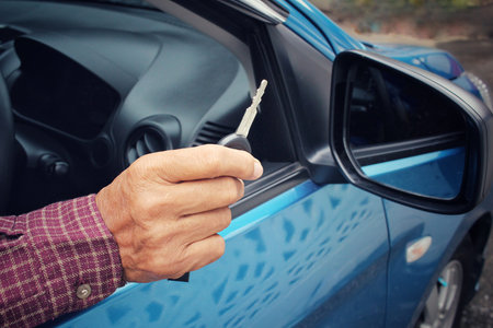 Man holding keys with car
