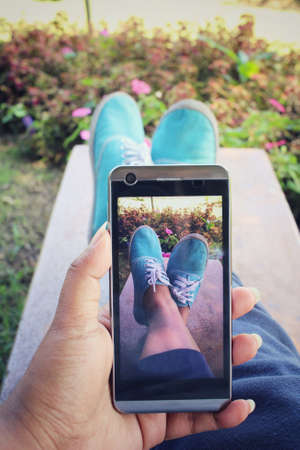 Taking photo of sneakers with smart phoneの写真素材