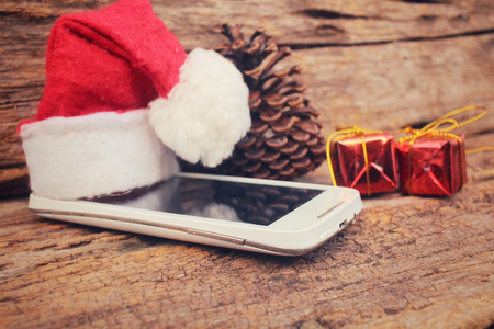 Smart phone and gift with christmas hatの写真素材