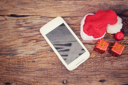 Smart phone and gift with christmas hatの写真素材