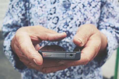 Senior using smart phone on the roadの写真素材