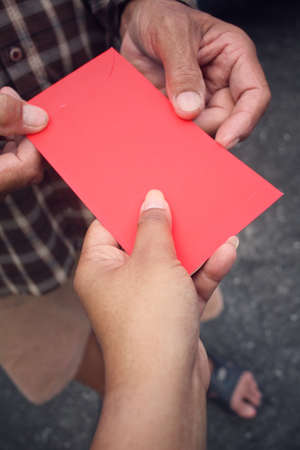Red envelope on hands in chinese new year festivalの写真素材