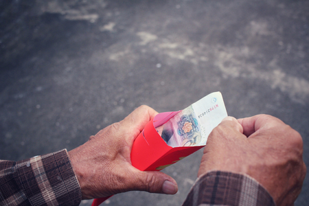 Red envelope on hands in chinese new year festivalの写真素材