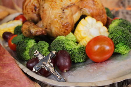 Roasted turkey with vegetables and cross for thanksgiving day