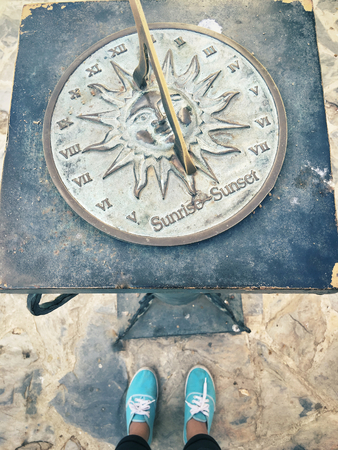 Selfie of shoes with old sun clock dialの写真素材