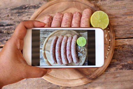 Taking photo of raw sausageの写真素材