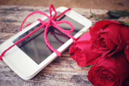Red roses with smart phoneの写真素材