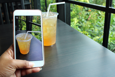 Taking a photo of lemon drink with smart phoneの写真素材