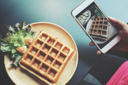 Taking a photo of belgium waffles with smart phoneの写真素材