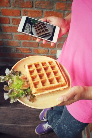 Taking a photo of belgium waffles with smart phoneの写真素材