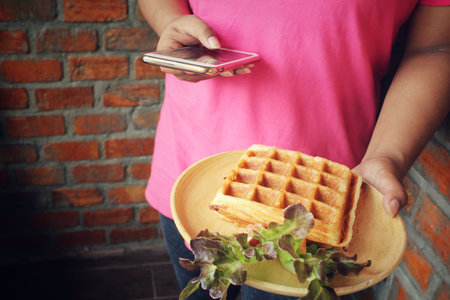 Taking a photo of belgium waffles with smart phoneの写真素材