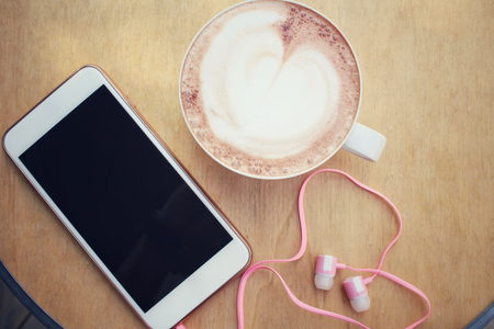 Smart phone with hot chocolateの写真素材